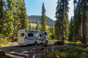 beautiful-campsite-mountains-with-rv-wooden-bench.jpg